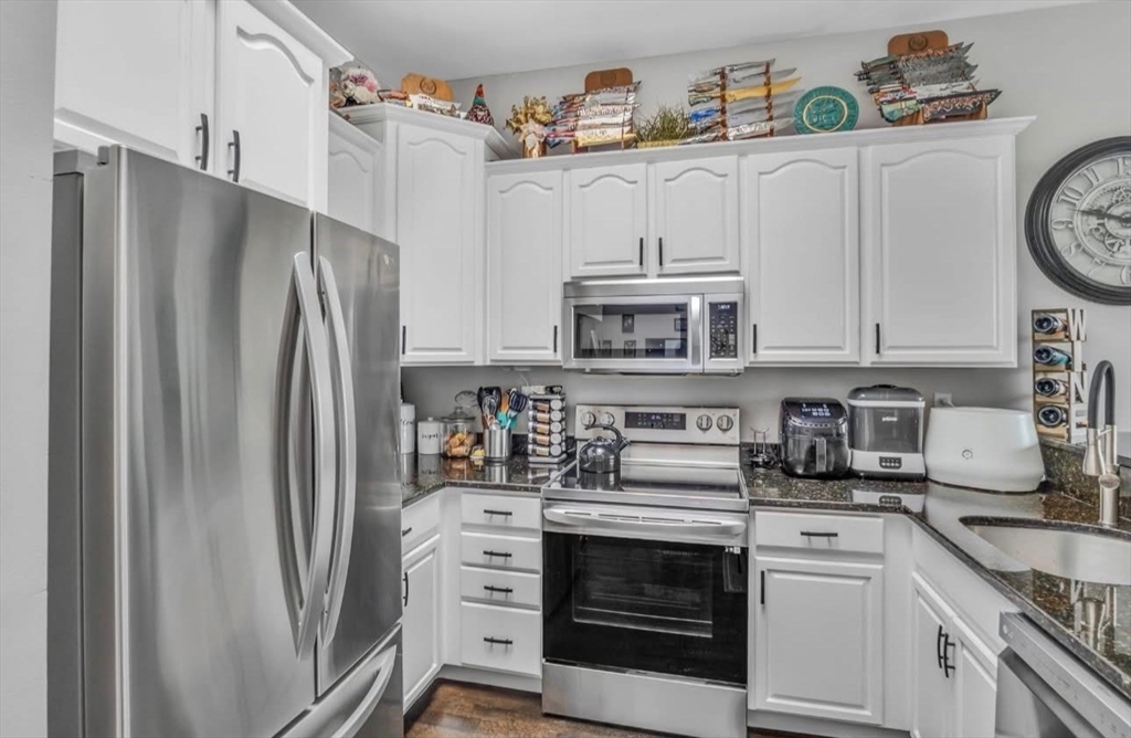 7 Central Square, Unit 307 Lynn, MA 01901 - Photo 3 of 9 a kitchen with stainless steel appliances a refrigerator stove and white cabinets
