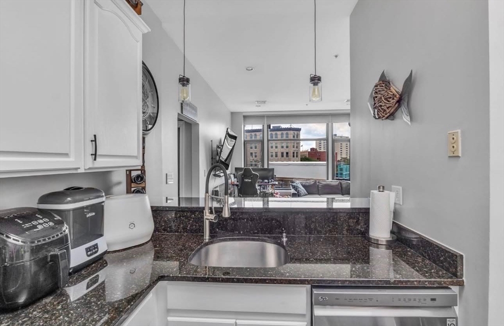 7 Central Square, Unit 307 Lynn, MA 01901 - Photo 4 of 9 a kitchen with stainless steel appliances granite countertop a sink stove and cabinets