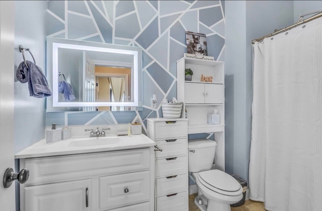 7 Central Square, Unit 307 Lynn, MA 01901 - Photo 6 of 9 a bathroom with a sink vanity mirror and toilet