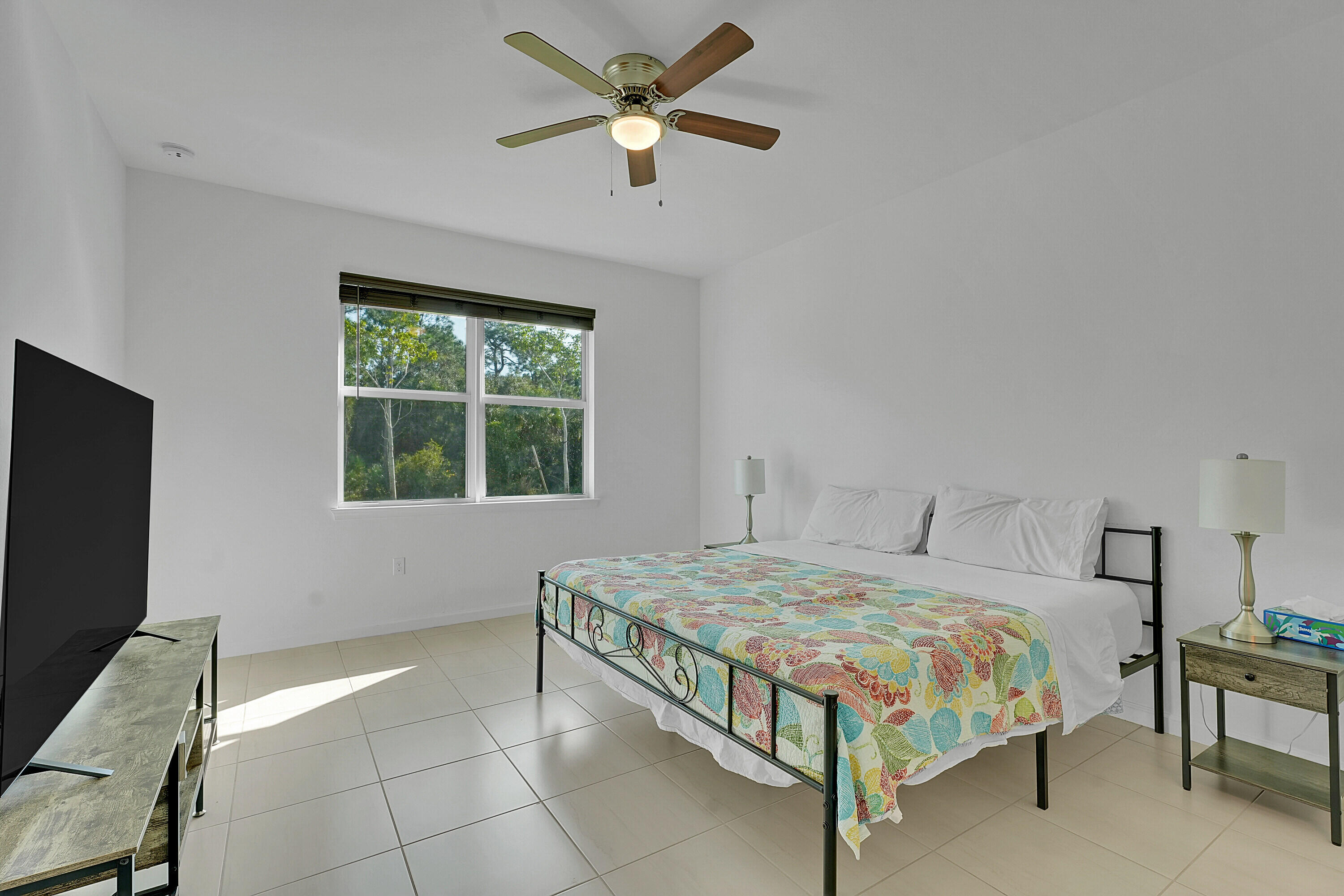 9765 Southwest Meridian Way Stuart, FL 34997 - Photo 11 of 46 a bedroom with a bed and a window