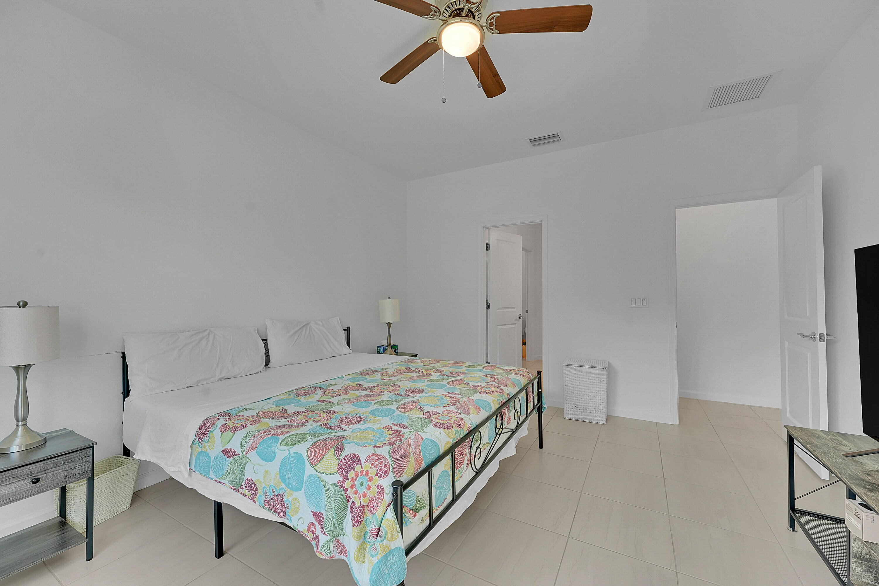 9765 Southwest Meridian Way Stuart, FL 34997 - Photo 12 of 46 a bedroom with a bed a dresser and a window