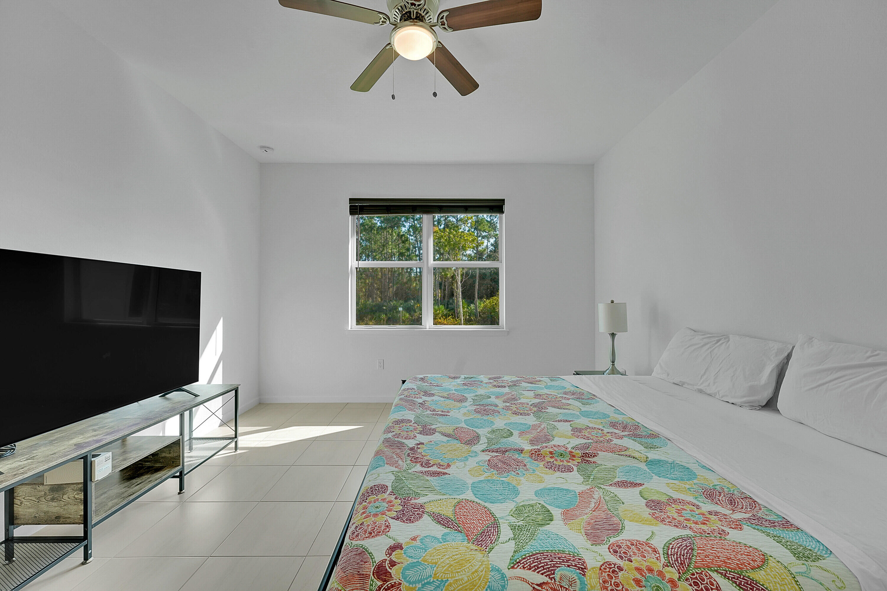 9765 Southwest Meridian Way Stuart, FL 34997 - Photo 13 of 46 a bedroom with a bed and a flat screen tv