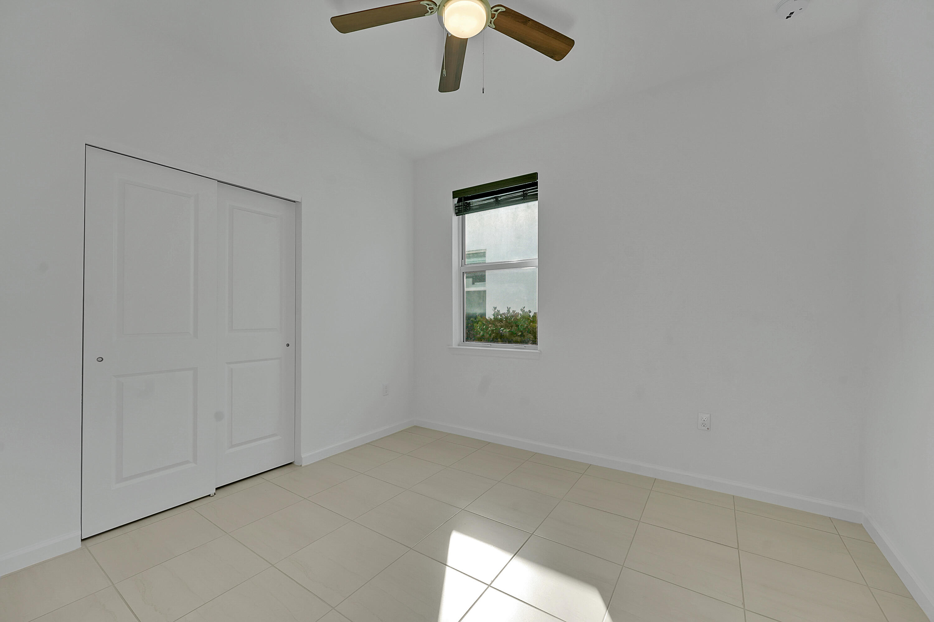 9765 Southwest Meridian Way Stuart, FL 34997 - Photo 22 of 46 an empty room with a fan & a window