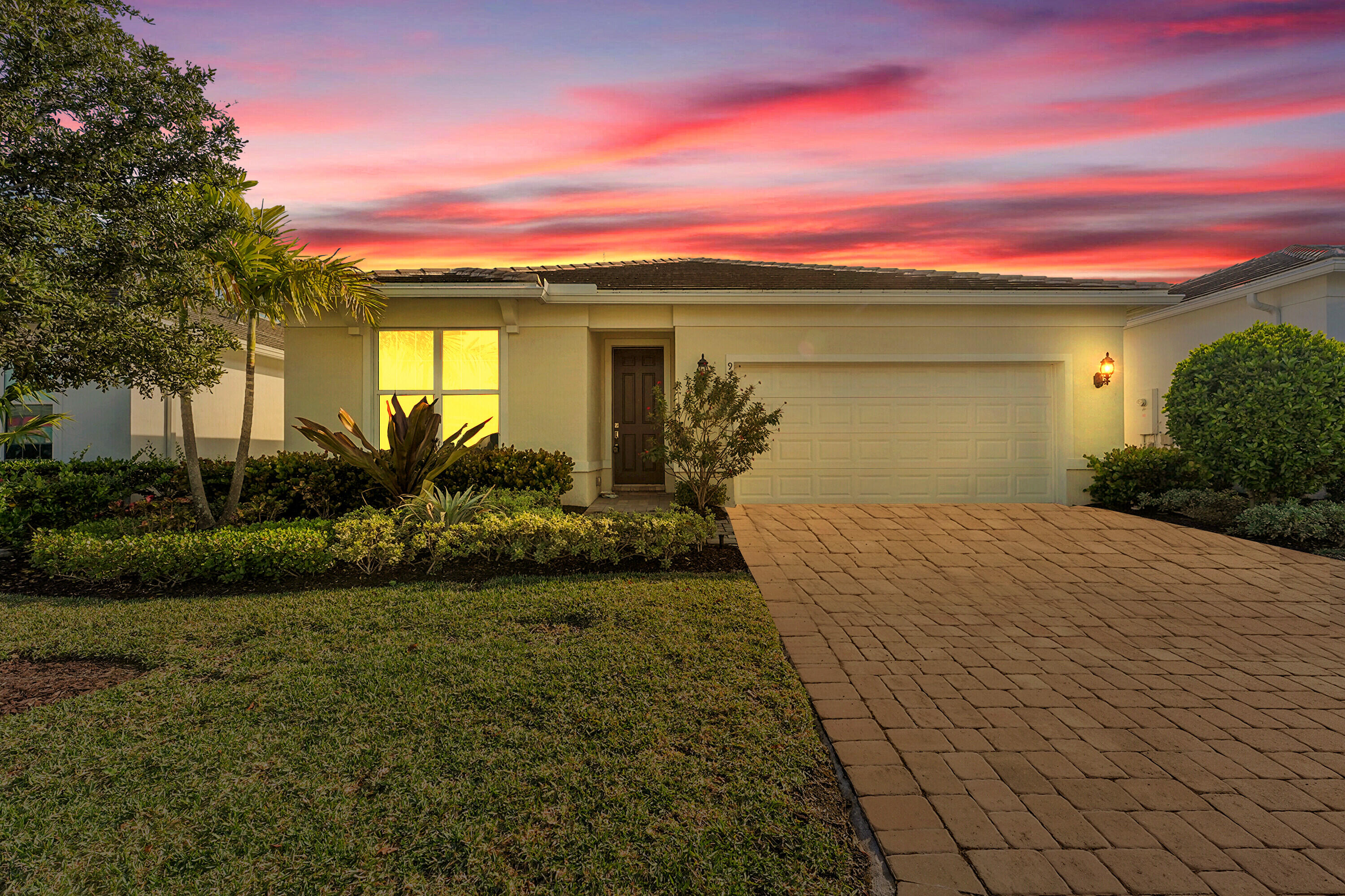 9765 Southwest Meridian Way Stuart, FL 34997 - Photo 45 of 46 a front view of a house with a yard and potted plants