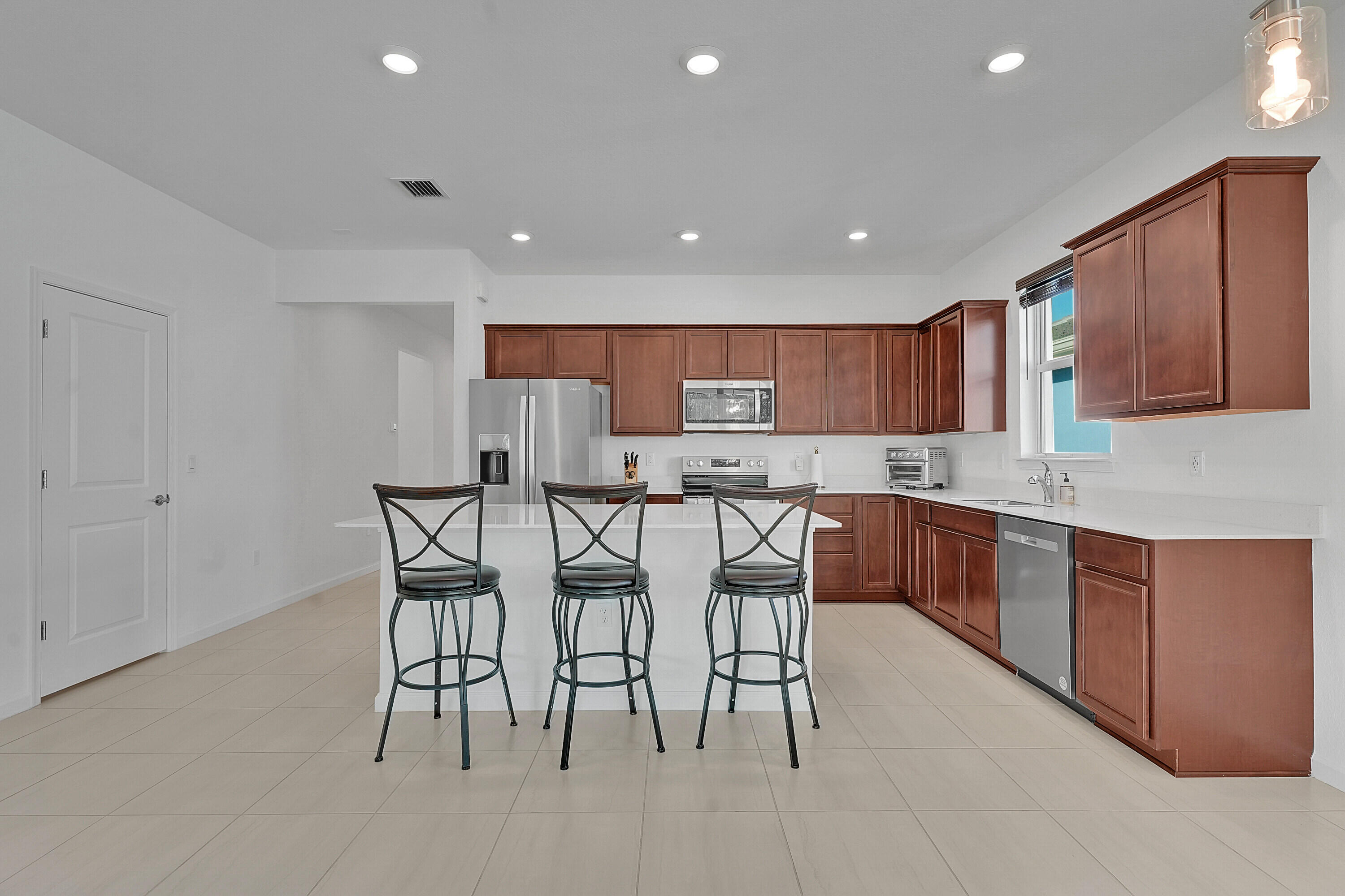 9765 Southwest Meridian Way Stuart, FL 34997 - Photo 7 of 46 a kitchen with a table and chairs in it