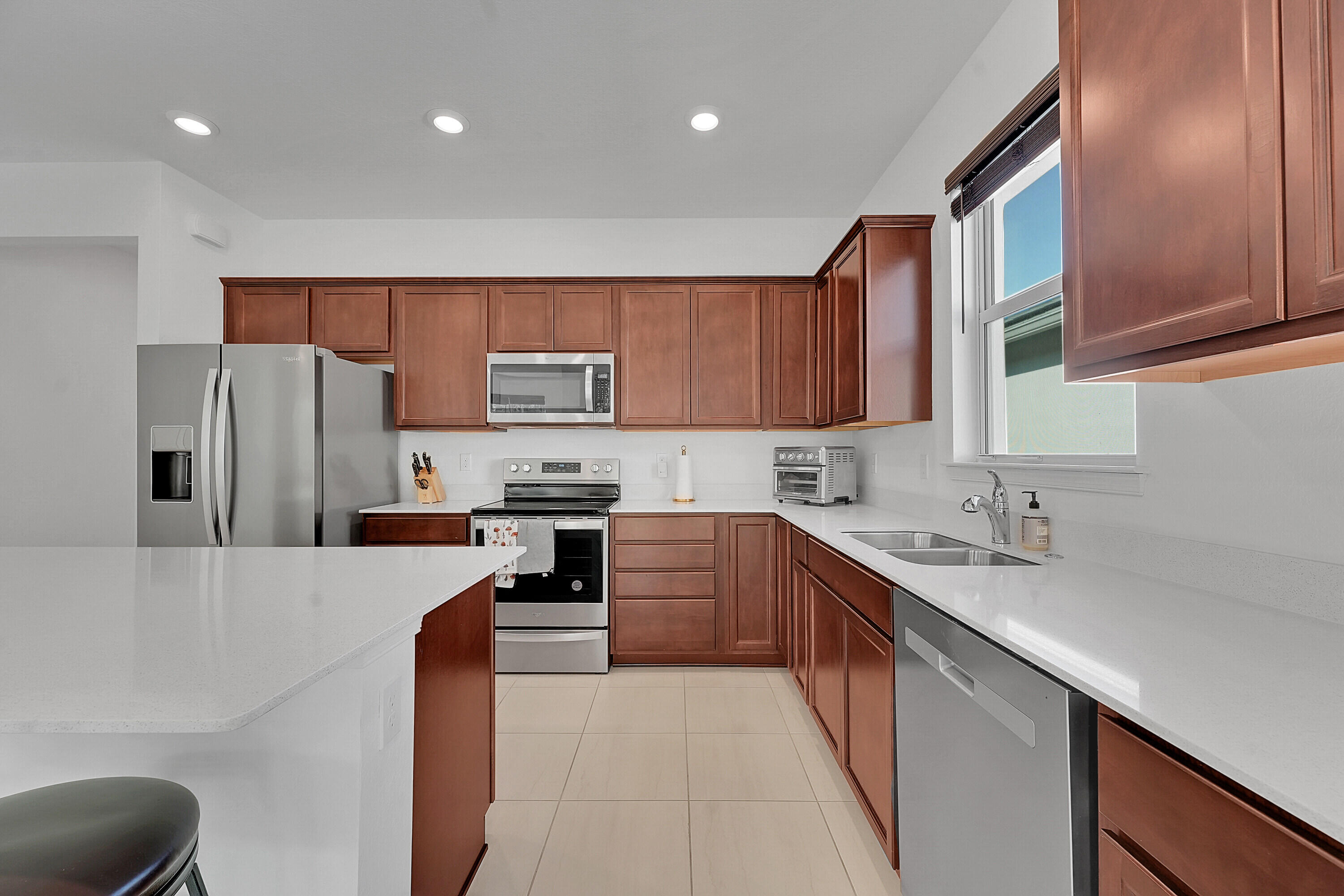 9765 Southwest Meridian Way Stuart, FL 34997 - Photo 8 of 46 a kitchen with stainless steel appliances a refrigerator sink and microwave