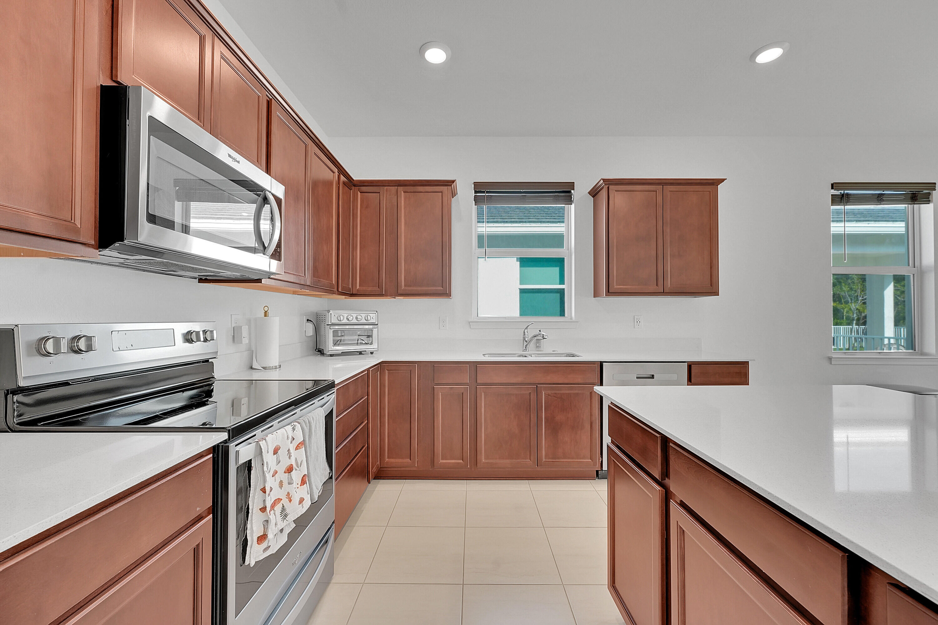 9765 Southwest Meridian Way Stuart, FL 34997 - Photo 9 of 46 a kitchen with stainless steel appliances granite countertop a sink and a stove