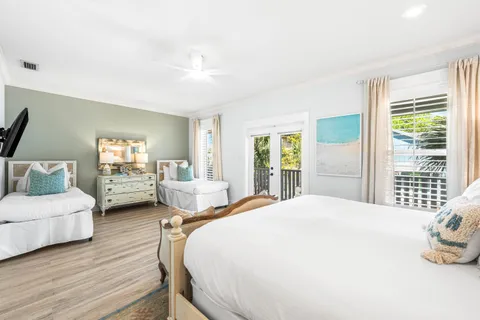 a spacious bedroom with a bed and wooden floor