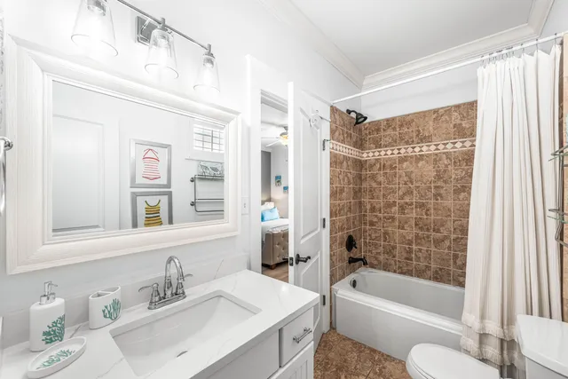 a bathroom with a bathtub shower sink vanity and toilet