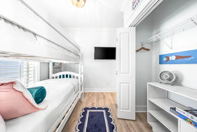 a living room with a bed and a flat screen tv