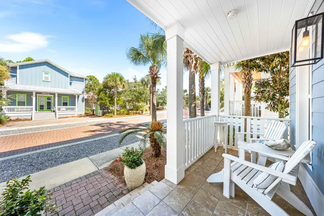 a front view of a house with outdoor seating and a potted plant