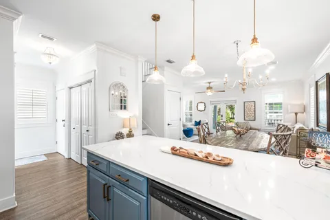 a large kitchen with kitchen island a stove a sink a center island and wooden floor