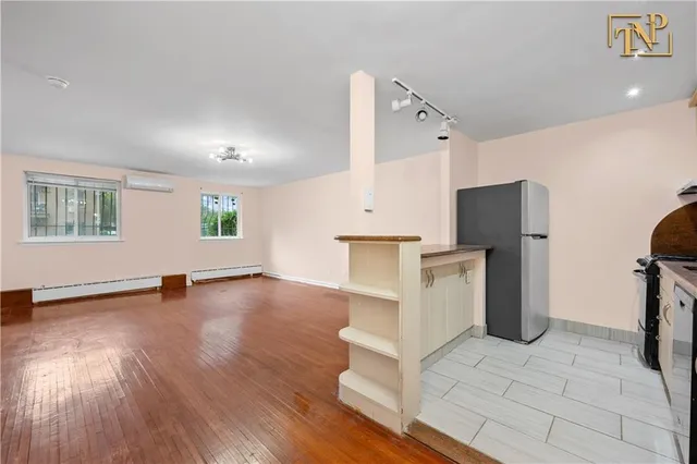 a view of a kitchen with a sink a refrigerator and window