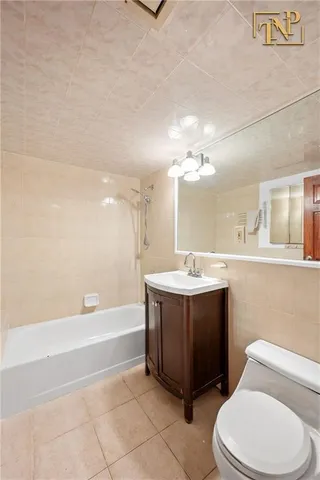 a bathroom with a bathtub sink vanity mirror and toilet