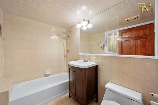 a bathroom with a sink a toilet a mirror and bathtub