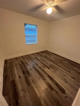 a view of a room with wooden floor and ceiling fan