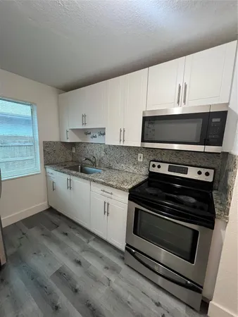 a kitchen with granite countertop a stove and a sink