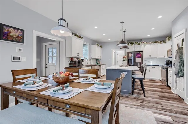 a living room with stainless steel appliances kitchen island furniture a rug and a view of kitchen