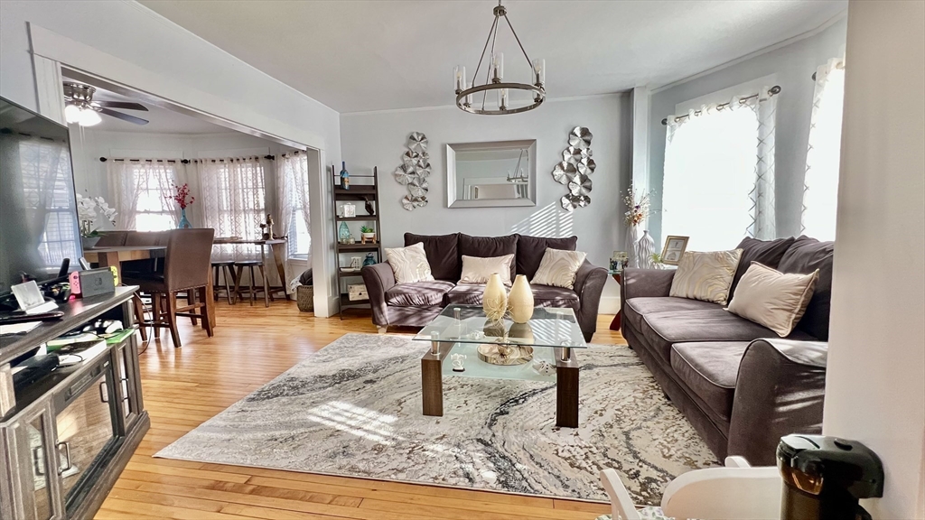 603 Temple Street Whitman, MA 02382 - Photo 10 of 40 a living room with furniture wooden floor and a chandelier