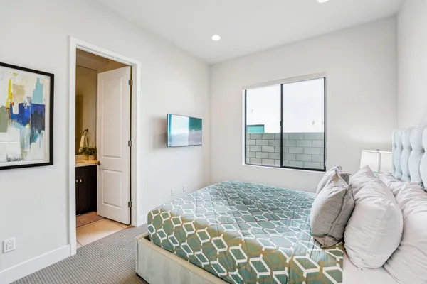 a bedroom with a bed and a painting on the wall