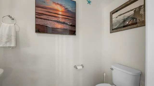 a bathroom with a toilet and a picture on the wall