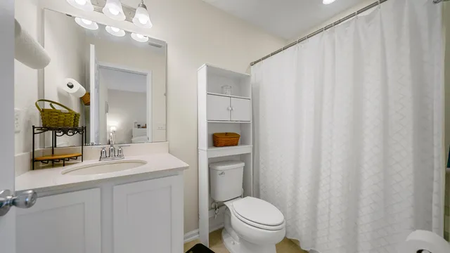 a bathroom with a granite countertop sink vanity mirror and toilet