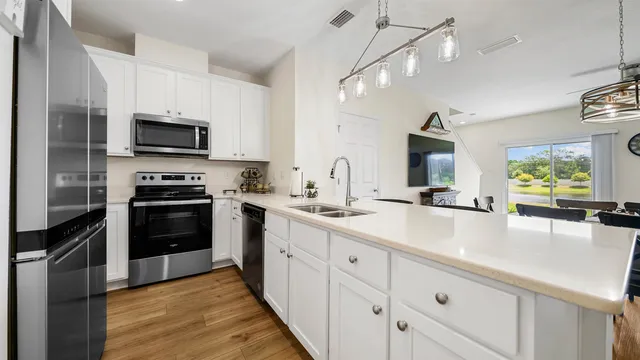 a kitchen with stainless steel appliances a stove sink microwave and cabinets