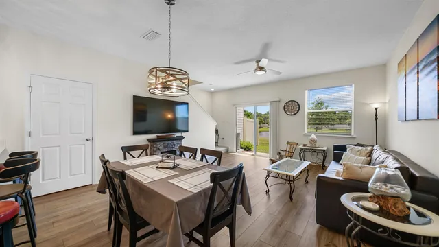 a living room with furniture a flat screen tv and a large window