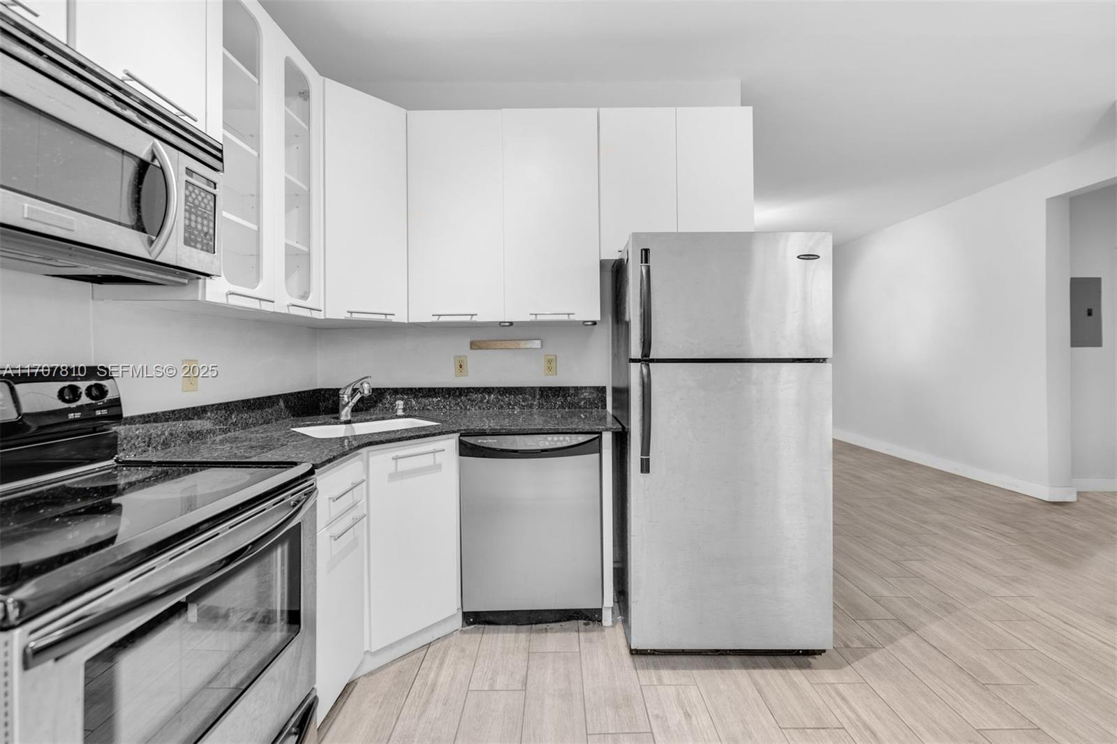 1622 Bay Road Miami Beach, FL 33139 - Photo 11 of 24 a kitchen with a refrigerator and a stove top oven