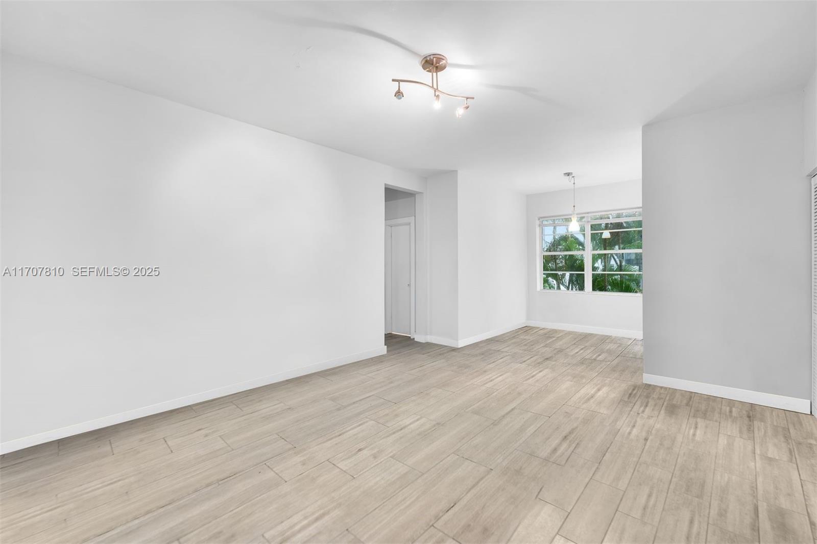 1622 Bay Road Miami Beach, FL 33139 - Photo 6 of 24 wooden floor in an empty room with a window