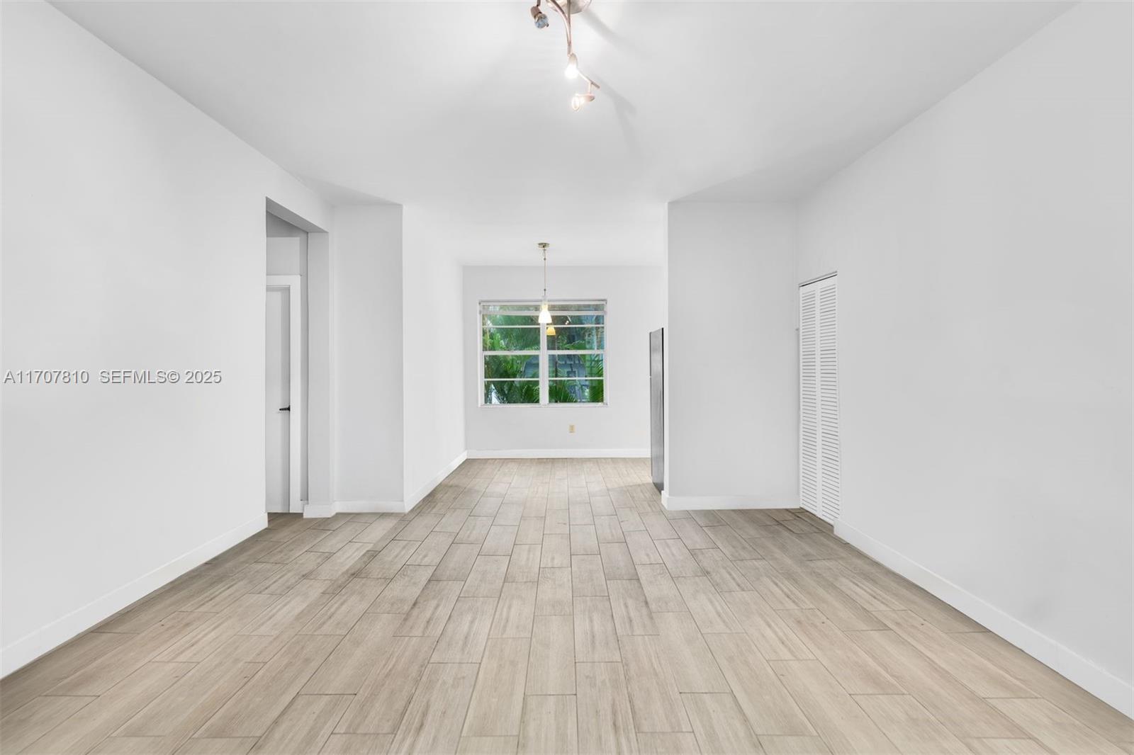 1622 Bay Road Miami Beach, FL 33139 - Photo 7 of 24 an empty room with wooden floor and windows