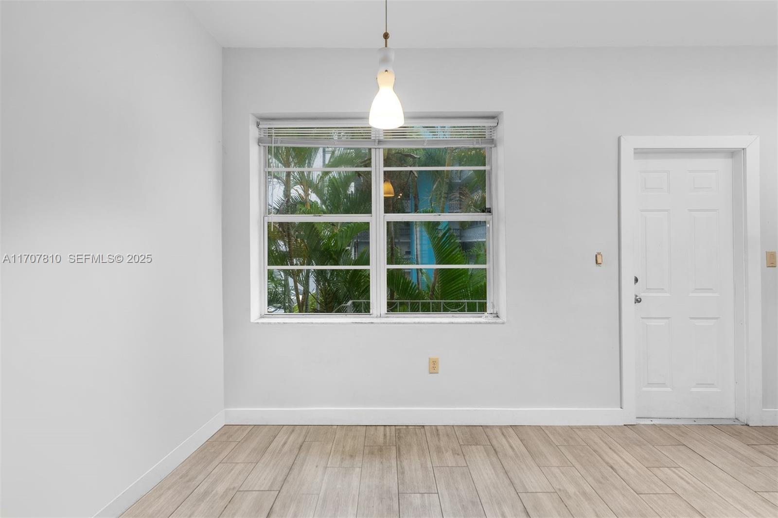 1622 Bay Road Miami Beach, FL 33139 - Photo 8 of 24 an empty room with wooden floor and windows