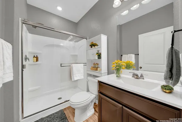 a bathroom with a sink a toilet and shower