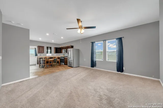 a view of a livingroom with a ceiling fan and window