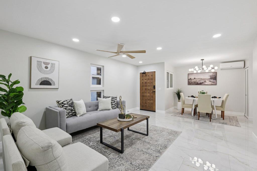 a living room with furniture and a dining table with wooden floor