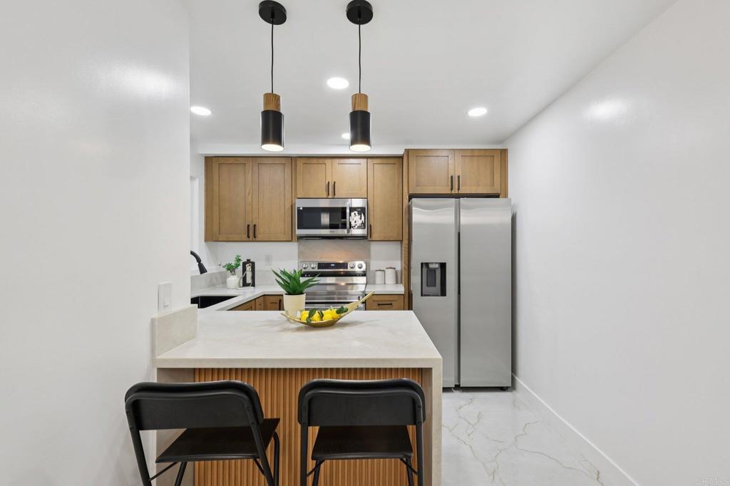 2600 Torrey Pines Road, Unit A13 La Jolla, CA 92037 - Photo 15 of 65 a kitchen with stainless steel appliances a sink and a refrigerator