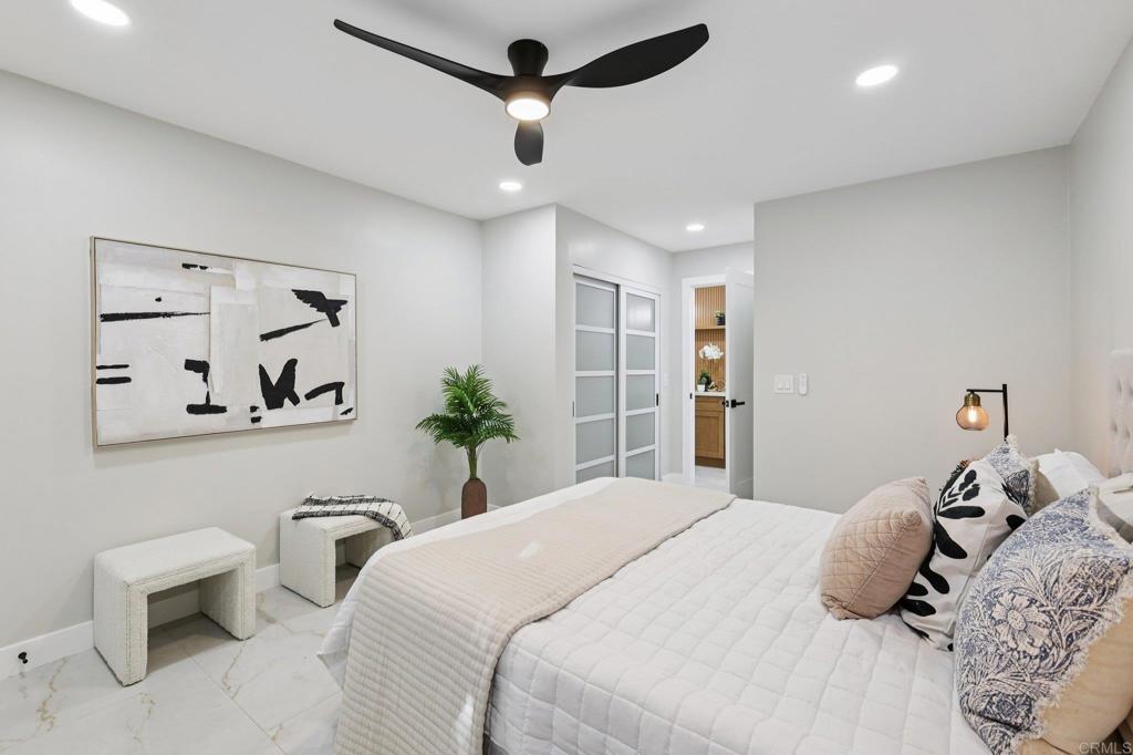 2600 Torrey Pines Road, Unit A13 La Jolla, CA 92037 - Photo 16 of 65 a bedroom with a large bed and a chandelier