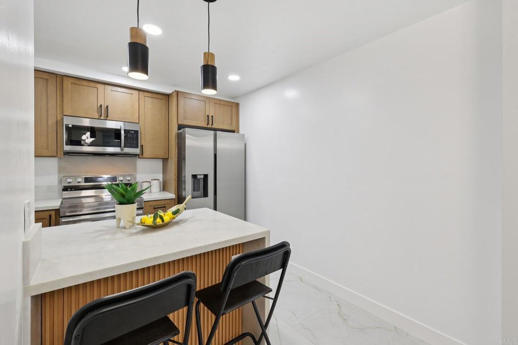 2600 Torrey Pines Road, Unit A13 La Jolla, CA 92037 - Photo 17 of 65 a kitchen with stainless steel appliances a refrigerator and microwave