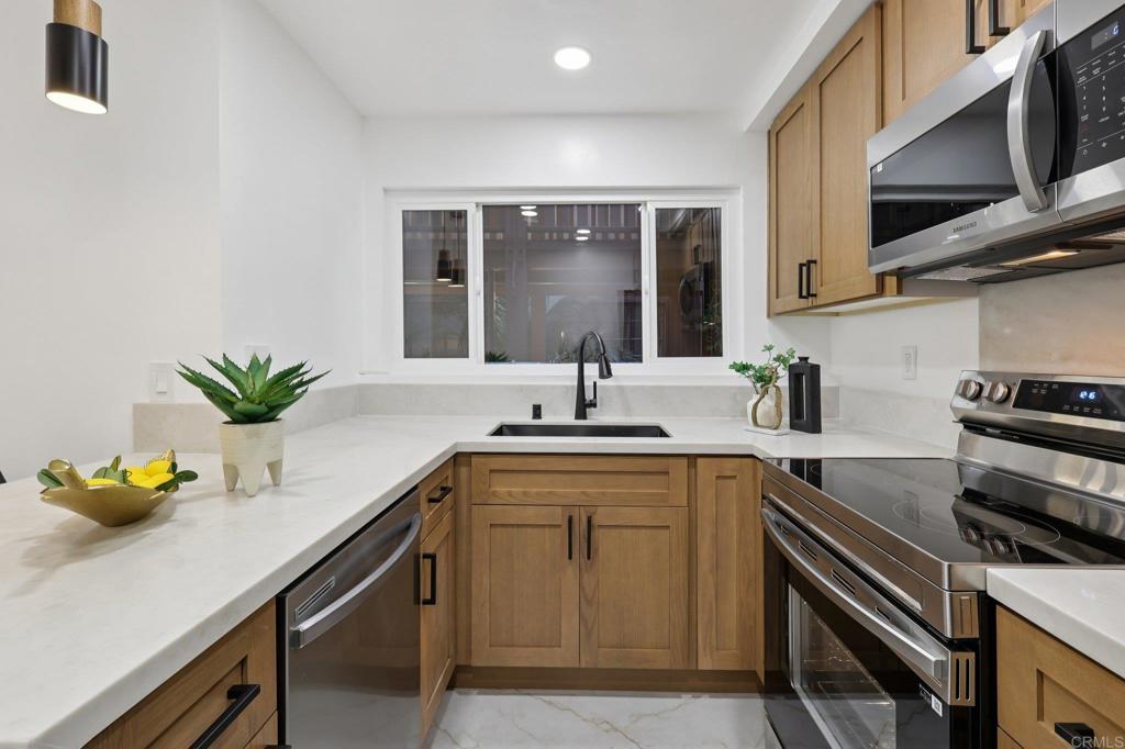 2600 Torrey Pines Road, Unit A13 La Jolla, CA 92037 - Photo 19 of 65 a kitchen with stainless steel appliances granite countertop a sink a stove and cabinets
