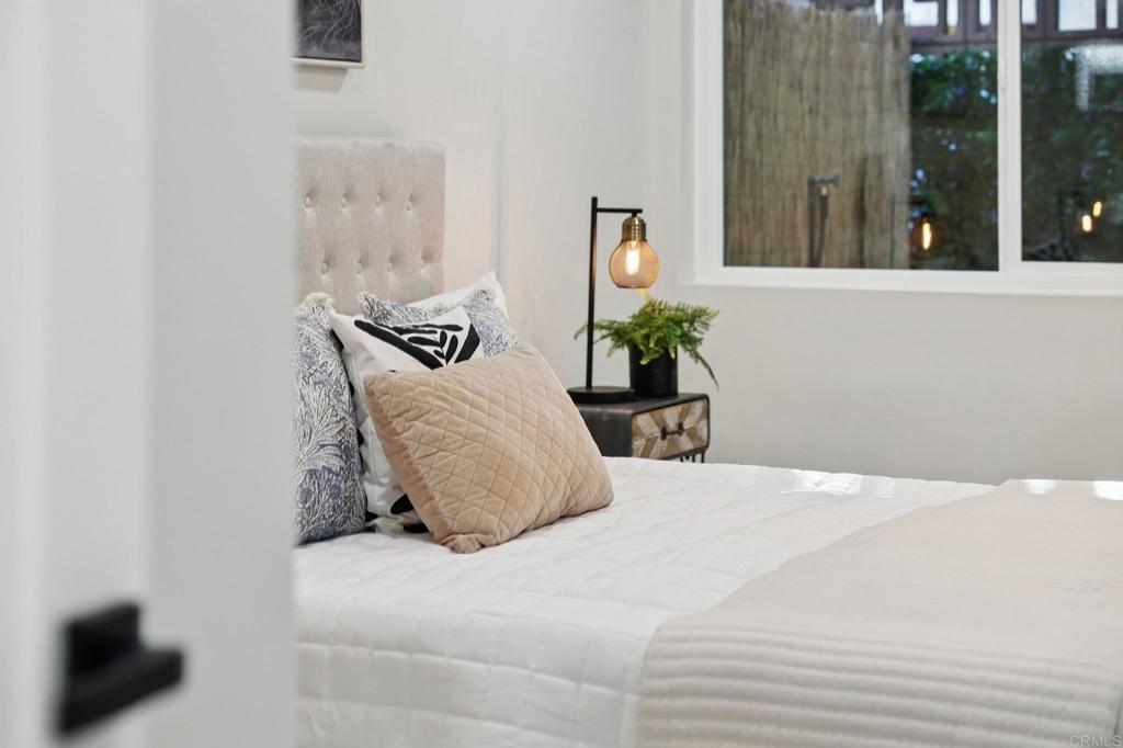 2600 Torrey Pines Road, Unit A13 La Jolla, CA 92037 - Photo 33 of 65 a bedroom with a large bed and a potted plant next to a window