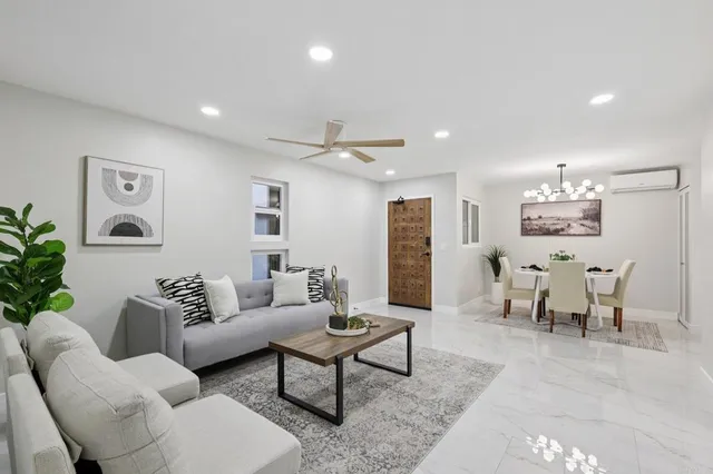 a living room with furniture and a dining table with wooden floor