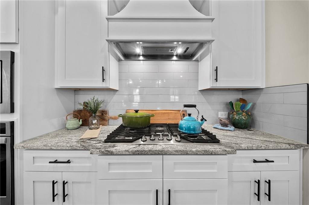 392 London Road Ball Ground, GA 30107 - Photo 14 of 53 a kitchen with granite countertop a sink a stove and cabinets