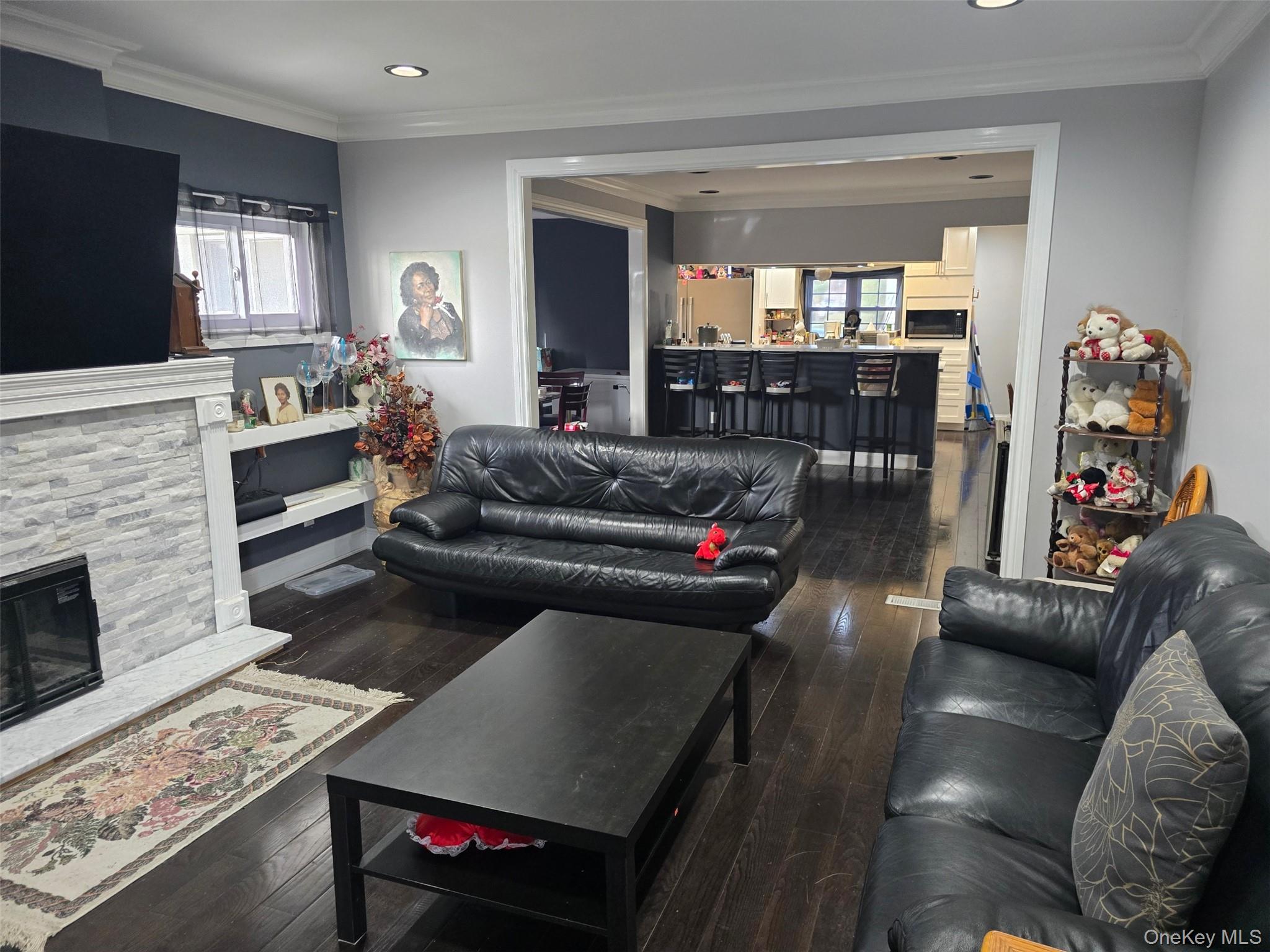 192-01 110th Road Queens, NY 11412 - Photo 6 of 11 Living area with ornamental molding, dark wood-style floors, a fireplace, and recessed lighting