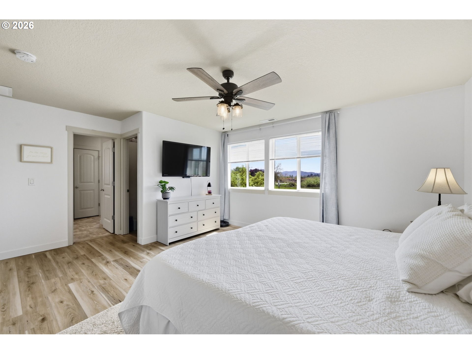 5442 Pranz Place Eugene, OR 97402 - Photo 13 of 34 a bedroom with a large bed a flat tv screen and a chandelier