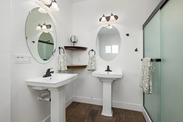 a bathroom with a granite countertop double vanity sink and a mirror
