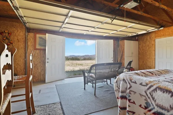 a bedroom with furniture and a large window