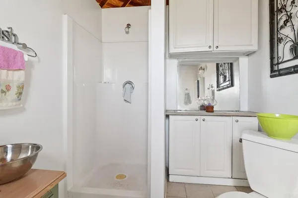 a bathroom with a granite countertop sink a toilet and shower