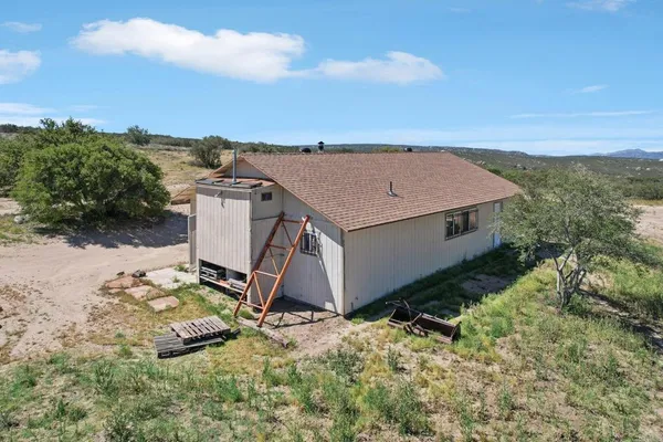 an aerial view of a house with table and chairs