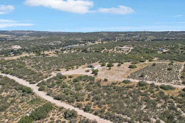 an aerial view of house with yard and mountain view in back