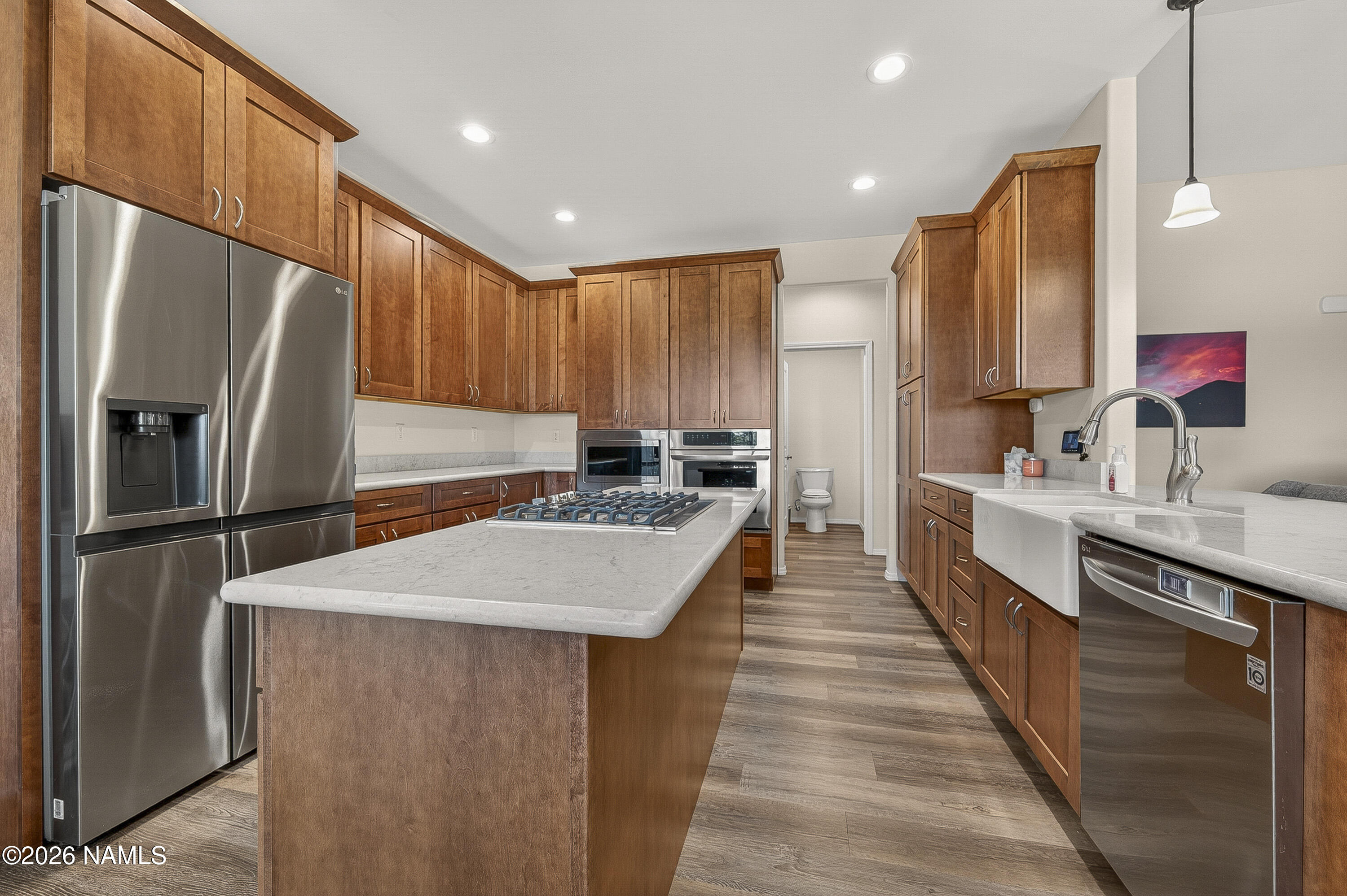 6560 Johnson Ranch Road Flagstaff, AZ 86004 - Photo 11 of 57 a kitchen with stainless steel appliances a refrigerator sink and wooden cabinets